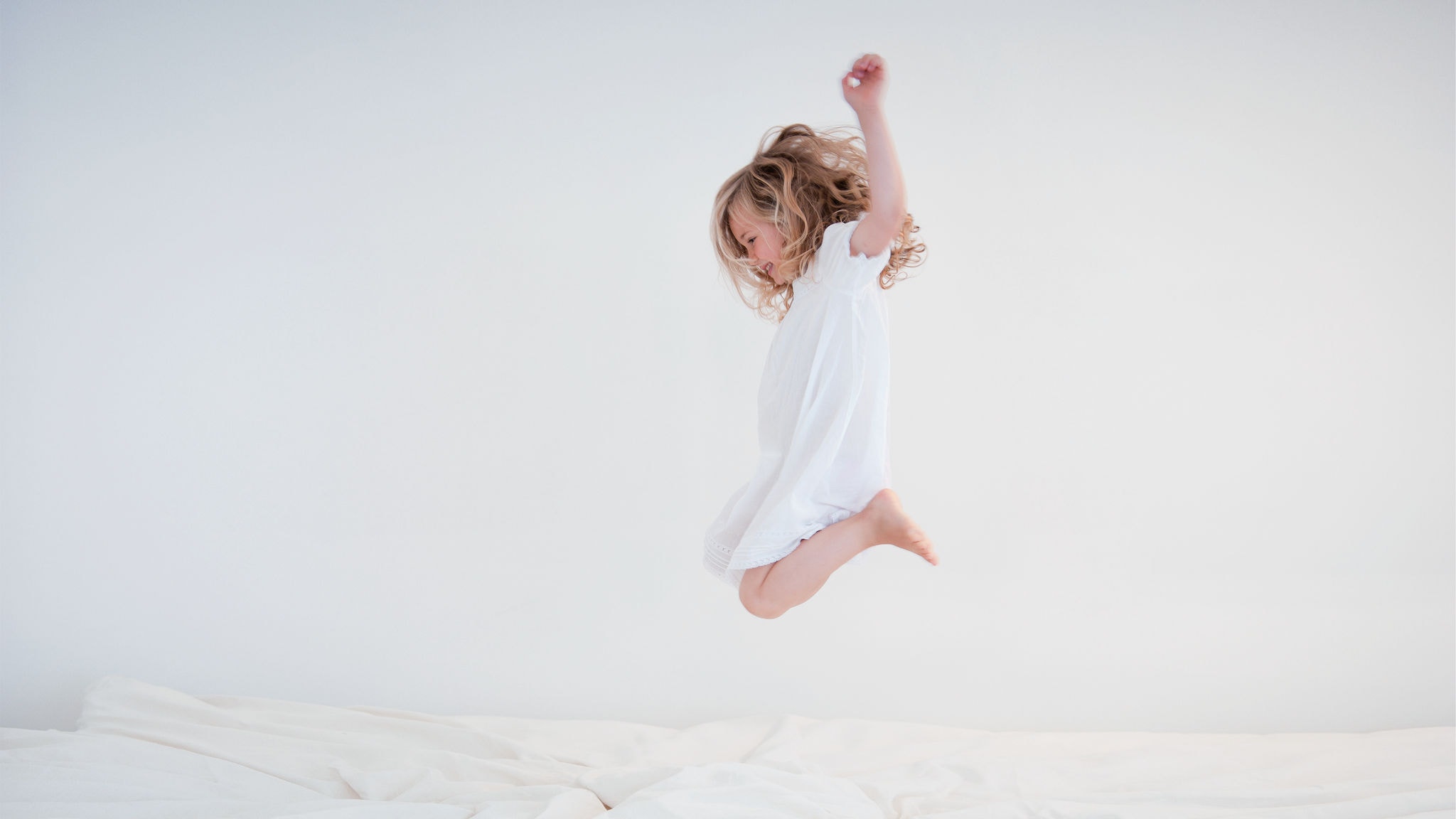 Enfant sautant sur le lit profitant d'un air frais et propre